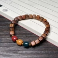 Chinese black rosewood bracelet with square beads and colorful spacer beads on a book - 7mm Three-Color Cube Beads