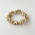 Elegant champagne gold satin scrunchie with a glossy silk finish on white background - Apricot