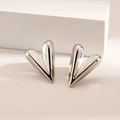 Polished silver heart stud earrings with minimalist aesthetic on white display - 3D Heart / Steel