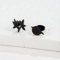 Detail of asymmetric black metal earrings featuring bird and leaf branch silhouette designs - Bird & Leaf / Black