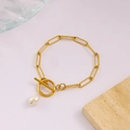 Dettaglio del bracciale a catena dorata a graffetta con chiusura OT e perla bianca - Bracciale