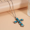 Gros plan du pendentif croix vintage avec strass bleus sur un collier chaîne argenté - Croix en Argent avec Pierre Précieuse Bleue (HN8787)
