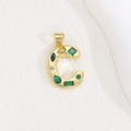 Macro shot of gold letter C pendant with colorful zircon stones and polished metal details - Letter C