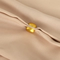 Detail of golden magnetic scarf clip fastening a beige silk fabric with a smooth finish - Bright Gold