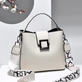 Cream white bucket bag with wide letter-pattern strap and black buckle accent - White Litchi Grain