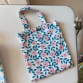Dettaglio della piccola borsa in cotone floreale con bottone a pressione dorato lucido - Base Bianca Foglia Blu Fiore Rosa(T-2)