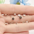 Nahaufnahme silberner Sechskant-Abstandshalter für DIY-Schmuckherstellung auf einer Hand - 4mm / Weißgold