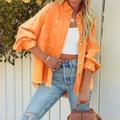 Close-up of orange distressed denim jacket with frayed hem and vintage washed finish - S / Orange