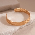 Gedetailleerde weergave van een goudkleurige gehamerde armband op witte minerale stenen - Goud - Klein