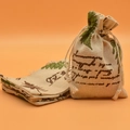 Linen drawstring pouch with green leaf print and cursive text on orange backdrop - English Leaves