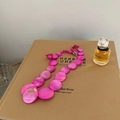 Dettaglio della collana bohémien in conchiglia rosa con texture naturale su sfondo di libro - Rosa Rosso / Catena Argentata
