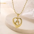 Collier cœur doré avec pendentifs garçon et fille en cristal sur fond texturé blanc - Style Garçon et Fille (24698)