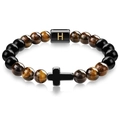 Macro detail of Tiger Eye beaded bracelet with black cross and golden H letter charm - Letter H