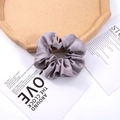 Dettaglio di un grande elastico per capelli in raso grigio su vassoio in sughero - Grigio
