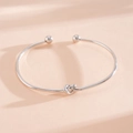 Verfijnd detail van een zilveren minimalistische open armband met knoopontwerp - Knoop Open Armband / Zilver