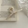 Dettaglio della grande pinza per capelli perlata a sirena su pagina di libro - Incrociato / Bianco perla/Oro