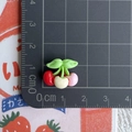 Detailed view of mini resin cherries in red white and pink with green leaves on scale mat - Three-color Small Cherries