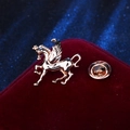 Elegant gold pegasus brooch with a glossy metal finish on a red velvet surface - Gold Pegasus