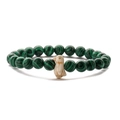 Macro detail of green malachite beads and a white penguin pendant on an elastic bracelet - Green Peacock Stone
