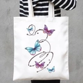 White canvas tote bag featuring vibrant butterfly prints and stars on the front - Flying Butterflies (STD707-I)