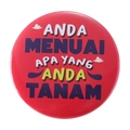 Red circular tinplate badge with colorful motivational text and cloud illustrations - ANDA MENUAI APA YANG ANDA TANAM