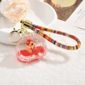 Capybara acrylic liquid sand keychain with red fluid and a strawberry capybara charm - Capybara Quicksand (Lanyard Style) / Television
