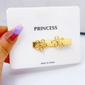 Detail of a golden metal hair clip with hollow floral pattern on a white princess card - 3.5cm Flower
