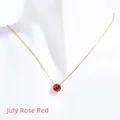 Close-up of July birthstone necklace with rose red zircon and golden chain on a bust - July Rose Red