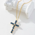 Gold-plated necklace with a blue gemstone cross pendant on a white marble pillar - Gold/Blue Gemstone Cross/K