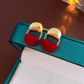 Macro view of Christmas tree earrings with red flocking and gold metal chains - Red Velvet Geometric Splicing Stud Earrings