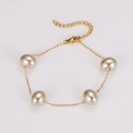 Vista dettagliata del bracciale a catena dorata con perle ovali e chiusura a moschettone - Bracciale Oro