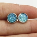 Macro shot of 8mm sky blue druzy stud earrings in silver frame held by hand for size - Sky Blue (18)