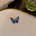 Exquisite blue enamel butterfly brooch with inlaid gem on a gold-rimmed white plate - Little Butterfly / Blue