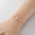 Minimalist gold chain bracelet with horizontal cross pendant shown on the wrist - 340-Horizontal Cross