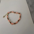 Detail of 14K gold plated bracelet with pink evil eye enamel and red zircon crystals - Orange
