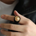 Close-up of a vintage men's lion head ring featuring gold relief on a black resin band - US 7 / Black and Gold