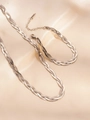 Detail of silver woven herringbone chain necklace and bracelet on beige satin background - Silver Necklace