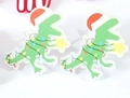 Green dinosaur stud earrings with Christmas lights and a red hat on white background - Dinosaur