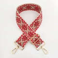 Close-up of geometric jacquard bag strap with gold metal hooks and adjustable buckle - Red Green Floral