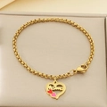 Gros plan du pendentif cœur Mama doré avec émail sur une chaîne de perles fine - Email Coloré Lettre Mama (KB203662-Z)