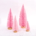 Set of four mini pink Christmas trees with round wooden bases in varying sizes - Pink