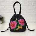 Détail de la broderie florale rose sur un petit sac seau en toile noire à cordon - Deux fleurs de bon augure