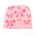 Detailopname van de roze gebreide muts met donkerroze jacquard strikpatronen - M (56-58cm) / Roze