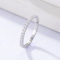 Macro shot of silver eternity ring with clear round cubic zirconia stones on white surface - US 5 / Silver