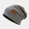 Detail of vintage striped knit beanie featuring a brown leather brand tag and metal rivets - M (56-58cm) / Black Stripe