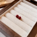 Detail shot of red bead stud earrings in golden settings on a wooden jewelry box pad - Red Round Bead Studs (17# Silver Earring Post)