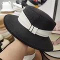 Detail of a black straw boater hat featuring a wide white ribbon and elegant bow accent - M (56-58cm) / Black