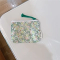 Vista dall'alto di una mini pochette in cotone a fiori verdi con cerniera e cordino - Floreale Verde Chiaro
