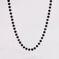 Macro shot of faceted black beads and gold links on a minimalist beaded necklace - Black