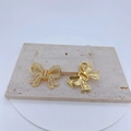 Détail d'un pendentif nœud plaqué or avec incrustation de zircon et dos ajouré ciselé - Doré